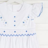 This white geometric sleeveless dress with tiny blue and white flowers. Perfect for this season! #smockedauctions #girlsfashion #smocked #smocking #spring #easter #classic #white #blue #flower #dress #champagnetastesippycupbudget