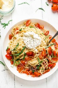 Angel hair spaghetti with a fresh raw tomato bruschetta sauce and burrata topping! This is the perfect luxurious summer pasta dish. The delicate bruschetta pasta complements your creamy, cool burrata perfectly and lets this amazing cheese take center stage at dinner time!