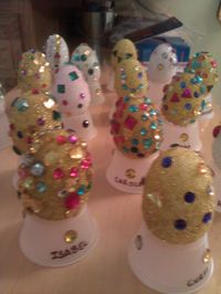 Fabergé eggs by preschool students studying Russia. Students painted styrofoam eggs with glitter paint and then they added stick-on gems! Stands are made by cutting out bottom of small, plastic cups.