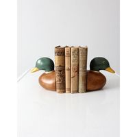 This is a pair of mid-century painted wood duck bookends.  The wooden mallard busts have rotund bases with charming painted detail.  Pads on bases to protect your surfaces.