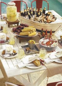 From Pottery Barn - nautical tablescape for a crab boil or any summertime dinner party. Mini champagnes or bottles of beer in boat on ice.