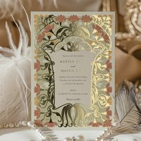 This stunning wedding invitation features an elegant Art Nouveau design, showcasing intricate floral patterns and organic shapes. The invitation is adorned with a rich palette of warm earth tones, including deep coral, olive green, golden yellow, and soft cream. The front of the card beautifully integrates these colors with flowing lines and floral motifs, creating a sophisticated and timeless look. The back of the card continues the theme with a simpler design, featuring three bold flowers and