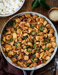 Jalapeno Chicken is bite-sized pieces of pan-fried chicken thighs, onions, and jalapeno peppers, all smothered in a sweet and salty sauce. Garnish the chicken with sesame seeds and serve it over a bed of rice for a flavorful and satisfying meal. I will also let you know how to cook the chicken in an air fryer!