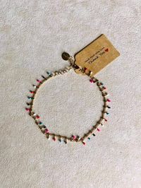 Adjustable gold-colored hypoallergenic stainless steel anklet with colored enamelled oval charms. Hook closure