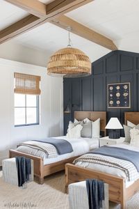 Here’s a shared boys bedroom design perfect for siblings! This twin boys room is masculine featuring a dark navy accent wall paired with two twin beds! Masculine boys bedroom inspiration for a shared kids room