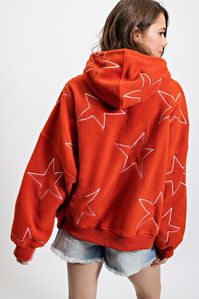 Orange Sherpa Pullover Hoodie with White Embroidered Stars Get ready to show off your star power with this oversized cozy sherpa hoodie! Embroidered stars add a playful touch, perfect for game day or just lounging around. Stay warm and stylish with this fun hoodie. Details Available in sizes S - L Adjustable Drawstring Hood Sherpa Kangaroo Pocket All Over Embroidered Stars 100% Polyester Sizing Small: 4/6, Medium: 6/8, Large: 10/12 Fit Model is wearing a small. This hoodie has an oversized, rela