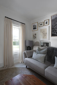 Longing for the final touch for your living room design? Instantly elevate your decor with drapery and curtains. A neutral linen material lends a relaxed elegance to the space. Click to order a free swatch Product Featured: Tailored Pleat Drapery in Nara Snow with Matte Black Hardware