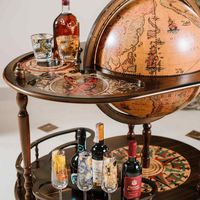 Product description : Like the Greek goddess of hunting Artemis, this globe attracts its prey and conquers them thanks to its majesty. It is a unique and original piece of furniture: the side trolley, made with a walnut-stained wooden structure, is ideal for welcoming guests into your home with great elegance and style. The sphere's internal compartment is remarkably large (50 cm in diameter), accommodating inside around 4/5 bottles and 12 glasses. The upper shelf has a large surface tray on which you can prepare your favorite drinks to your friends, for an authentic flavor after dinner. The globe has also a large and solid lower base, decorated with a wind rose made with natural water colours. On this surface ypu can store other bottles of liqueurs or useful objects to complete your drink