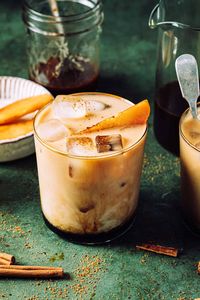 This apple crisp cold brew latte is a healthier, better-for-you version of the Starbucks fall favorite, and comes together for less than the cost of one latte!A glass of the apple crisp cold brew latte, sitting on a countertop