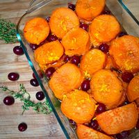 A baking dish filled with vegan simple maple cranberry yams (sweet potatoes).