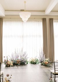 The George Madcap and Lounge in Milwaukee, WI. Grounded floral ceremony arch to circle around bride and groom. Spring pastel florals. Peony, sweet pea, delphinium, allium, ranunculus, roses, scabiosa. Photography by Autumn Silva Photography