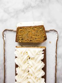 This carrot pound cake is a simple and moist loaf cake scented with spice and topped with a fluffy cream cheese buttercream!