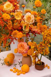 opulent citrus tone wedding reception floral centerpieces incorporating fresh tomatoes and oranges