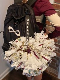 Cheer pom holders. They attach to bag with a metal clip. The straps keep poms separate. They are secured with snaps. Each pom holder comes plain but can be personalized with name or school. The metal clips are shown black. No pom poms included. Personalized holders can not be returned. Small fee for cancelled orders. Each strap was designed and are handmade by myself, it is not manufactured, so with that being said it important to be gentle when removing the poms from the holder, by holding each