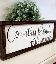 Beautiful farmhouse inspired Country Roads Take Me Home wood sign! Sign Sizes Available (Approximately): 20" in Length, 7" Tall 25" in Length, 9" Tall PLEASE NOTE: My signs are hand cut and are one of a kind. Each one has its own attributes that make it unique. For example, the size will vary some, frame stain and paint will vary depending on the character of the wood, and each sign will have its own unique wood chipping, knots or "imperfections" for that rustic look charm that I absolutely love