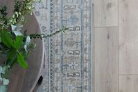 Green & blue vintage rug. Coffee table. Greenery. LVP flooring.