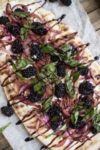 Goat Cheese and Blackberry Flatbread Pizzas: A homemade flatbread crust, grilled, and topped with fresh berries, melty cheese, fresh basil and sweet onions.