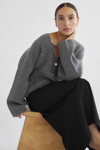 A mid to heavy weight wool cardigan with wide sleeves and a deep v neck. Front button closure and patch pockets for a chic look. It's like an outerwear piece for the transitional colder months.