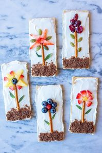 These Flower Garden Graham Crackers are so fun to make, beautiful to look at and delicious to eat! Both you and your kids will have a blast making them! You can go off the designs we have here or get super creative and design your own flowers! The possibilities are endless! #grahamcrackers #foodart #kidfriendly #fruit #flowers