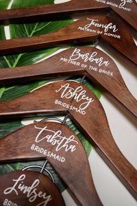 "Your best friends are going to love their own handwritten, personalized wooden hanger! Each hanger will be handwritten in white ink, unless you would like something different. When you're placing your order, please specify if you would like titles/date underneath the names. These hangers are $10 each. They will ship in 1-2 weeks of ordering. Rush shipping is available if you need it sooner than 2 weeks! If rush shipping is needed, please send me a message so I can accommodate this for you. HOW TO ORDER: -Choose the quantity of hangers you will need from the dropdown -When you checkout, please include your names (and titles/date if necessary) in the \"message to seller.\" I'll then send you my list of font styles  -Message me at any time with any questions! I would love to be your one stop