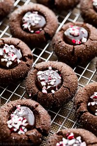 These chocolate peppermint thumbprints are the most delicious Christmas cookies! Soft chocolate peppermint flavored cookies rolled in sugar and filled with rich chocolate ganache. Don't forget the candy cane topping! Recipe on sallysbakingaddiction.com