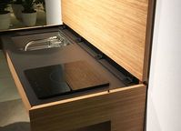 Invisible kitchen for extra-small spaces. The sink can be folded down and a cover lowers leaving with a desk.