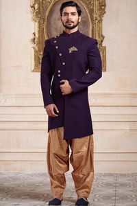 On heavy customer demand brought to you A Long and royal indian ethnic indian wear sherwani especially designed for men in order to make an occasion very especial. It is elegantly made with hands to bring about a feel about India. Look your best on your special day while you carry your sharp attitude with this indowestern sherwani paired with a churidar. Colored in purrple and black embellished with woven work. Available with gold color cotton silk churidar. Slip on to some matching mojari and a