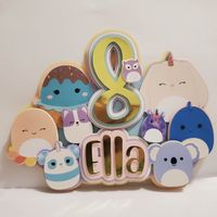 These Squishmallows have a way to anyone's heart! They are especially perfect for a Birthday Cake or Cupcake Toppers. I have carefully created and perfected these unique toppers. They are made out of a durable cardstock. The cake topper has a clear plastic stick that easily can be poked right into the cake when your topper arrives. (Not pictured in this listing)  (IMPORTANT:: Cupcake toppers pictured, are not toppers that come with this listing just an example. Toppers will match cake topper Squ