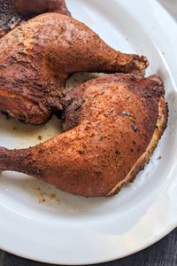 a photo of smoked chicken quarters in a brown sugar rub