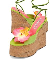 Product Description Sunflower our brand new wedged heel with a peep toe design perfect to complete a summer look. This style has a super cute soft green suede upper design with a striking pink flower, Summery ankle tie with a beaded finish to match and a Glitter cork wrap featuring the famous wolfe head plaque on the heel. Features 140mm heel height 60mm platform height 100% suede upper Suede soft leg tie Beaded tie finish Flower centre piece Leather lining Cork wedge cover Full leather insole f