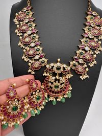 Kempu Mango Pattern Chandbali Guttapusalu Necklace with Matching earringsColor : GoldenSize : Nekclace Length : 16 Inches approx; Earring Length : 2.5 Inches ApproxStones : CZ Red Kemp Green Beads Pearls