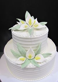 Two tier horizontal texture cake in white buttercream and white handmade flowers