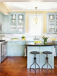 Robins egg blue is a fun departure from white cabinets and contrasts well with the dark floors, carrera marble and yellow walls.