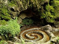 It is one of the greatest mysteries of the Isle of Avalon that two different healing springs, one touched red with iron, the other white with calcite, should rise within a few feet of each other from the caverns beneath Glastonbury Tor. Both have healing in their flow, and the one depicted is called the Glastonbury White Spring.