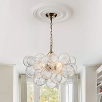 Exquisite design meets functionality with the Cluster Globe Chandelier from HUOKU. Featuring a stunning array of twisted ribbed glass globe shades in three sizes, this chandelier creates a layered, sophisticated look ideal for high-end and luxurious settings. Whether suspended above a dining table, installed in a hotel lobby, or gracing a restaurant, its elegant presence enhances any upscale environment. The chandelier includes a semi-flush mount option, achieved by shortening the chain, making it versatile for both pendant and ceiling mount installations. The intricate glass globes encase E12 sockets that are adjustable, allowing you to direct light where needed. This modern chandelier, with its bubble globe design and dynamic light projection, adds a touch of glamour to kitchens, dining