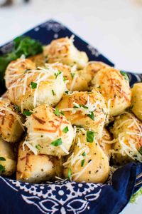 Parmesan Garlic Rolls are the BEST dinner rolls recipe! They're easy to make with Rhodes rolls and only take about 30 minutes of hands-on time. Add herbs for extra flavor. Bake them in a skillet if you want. You can make them with whole rolls or cut them into pieces for garlic parmesan pull-apart rolls. The perfect easy bread recipe. #ad #frozendough #easybreadrecipe #garlicbread