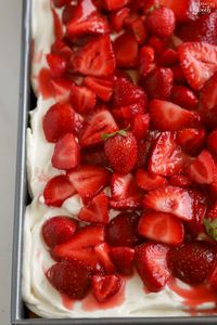 This homemade dessert is inspired by the classic dessert strawberry shortcake. It features a fluffy vanilla cake topped with whipped cream frosting and lots of syrupy strawberries.