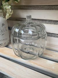 Fantastic decor piece for fall or Halloween!  This Anchor Hocking clear glass pumpkin shaped candy or cookie jar with a domed lid and figurative pumpkin shape is the perfect accent piece for your fall decor! Fill with candy corn, pine cones, acorns or mini lights!  No chips or cracks.  Measures-6 x 5 inches.