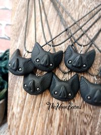 "The All Black Bats They are back! New series of 7 hand-sculpted bat heads with gemstones eyes (Hematite) These cute bats are made by me using polymer clay You will receive a random one from this batch They come with a cotton cord of 18\" with a 2\" extension cord They measure about 1\" tall and 1\" 1/2 wide (sizes vary slightly since they are individually hand-formed) The pendants I make are very resistant, but, depending on the piece or the details, they can break if they are dropped, so pleas