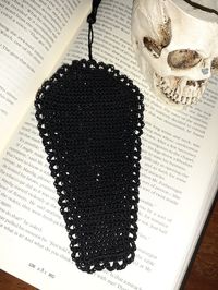 Gothic black lacy crochet coffin bookmark. Spooky with a hint of elegance, this marker pairs perfectly with your favorite tale of mystery.  Bookmark measures 5.75 inches long. With tassel, measures 10.25 inches long. Width is 3 inches.  Handmade with crochet thread. Wash by hand gently with warm water. Do not use bleach. Roll in towel to dry.