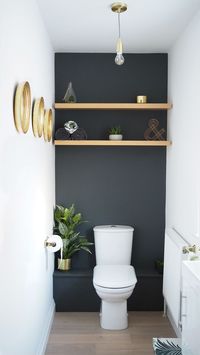 Dark grey downstairs bathroom diy home makeover with shelves in the alcoves and gold accents plus faux succulents and plants.