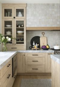 Modern farmhouse kitchen inspiration with white oak cabinets, black hardware, hidden range hood with tiled range hood, cararra marble countertops and white oak hardwood floors