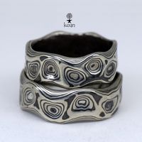 "These are unique mokume gane forged wedding or engagement rings, made of 14K white gold and sterling silver (oxidized). Can be ordered in pair as well as separatly up to your preferences in size, width, thikness and design. They are 100% handmade forged. The price will depend on final weight of the rings. Koan mokume gane jewellery My name is Andrew Seginovich, designer, maker and creator of Koan Mokume gane Jewelry. Welcome to my shop! The studio was created in 2005, and since that time I've b