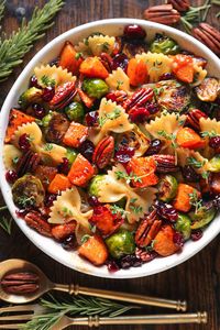 Butternut Squash Pasta Salad with Brussels Sprouts, Pecans, and Cranberries in a white bowl.