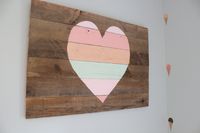 DIY’d the heart art above the bed using old barnwood and then painting on the stripes using colors drawn from the ice cream cones