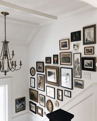 a refined and eclectic gallery wall of artwork in various frames, oval, round and others is a bold addition to the space