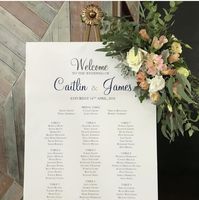 Wedding seating chart on gold easel, white roses and trailing gum