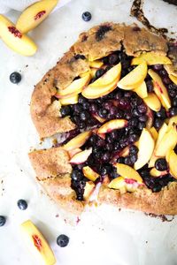 What I love about galettes is that they are as tasty as a traditional pie but there’s no pie dish, no pinching edges, and no complicated lattice crust. This Blueberry Peach Galettehas a buttery crust and is filled with jammy blueberries and sweet peaches.I like to call galettes the lazy man pie.Galette, or “flat cake” in French is a freeform crust cake or pie and is a classical French dessert. Galettes can be filled with all sorts of sweet berries and even savory vegetables such as mus…