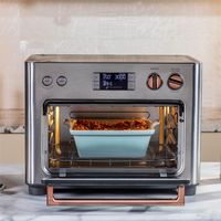 Adorn your counter with this handsome combination toaster oven and air fryer. Accented in rosy brushed copper, the stainless steel appliance not only graces the kitchen with a sleek silhouette, a modern palette and glam details. It also boasts fourteen cooking modes and a large temperature range that allow you to proof dough, dehydrate fruit and slow cook at low temps as well as bake pizza, roast vegetables and air fry appetizers at high heat. The rapidly heating appliance also serves as a toast