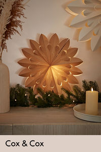 Inspired by the 70s style paper decorations, our light up paper star comes in a warming cinnamon colour which pairs beautifully with the glow of the light, adding a cosy feeling to your home.

Hang on your wall, or simply position on top of a surface, like a sideboard, for a touch of retro inspired magic in your space.

A simple, timeless decoration to add to any Christmas collection.